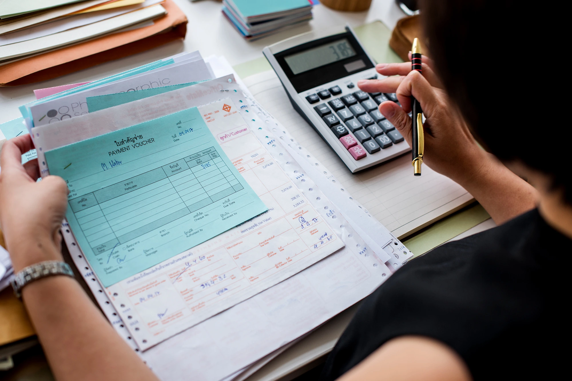 Tax-ready bookkeeping services with financial documents and a calculator, providing expert Bookkeeping Services Cambridge.