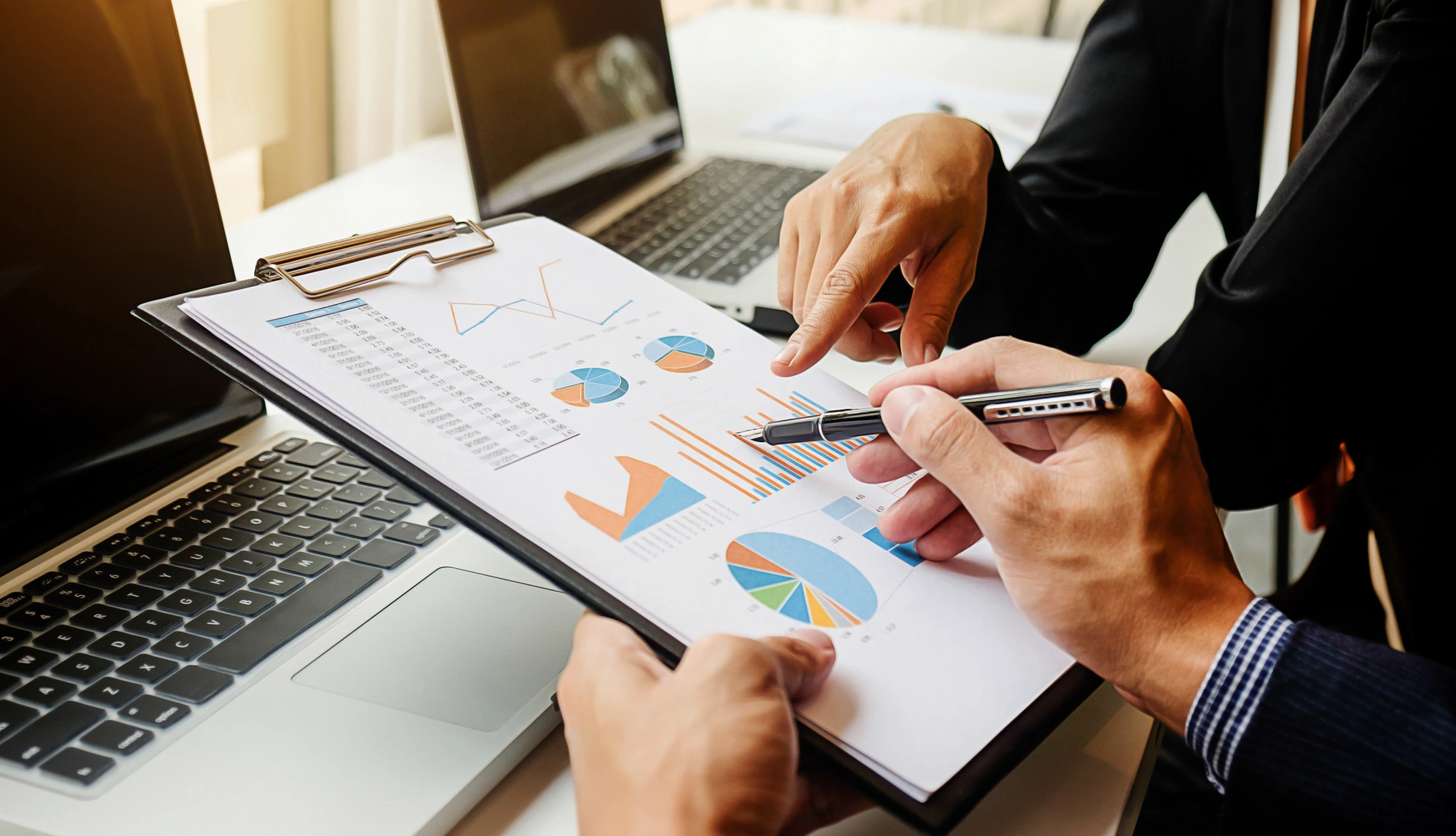Business professional reviewing financial documents and reports to manage financial data.