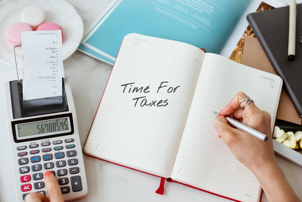 Tax professional reviewing documents and charts with calculator, representing Tax Planning Services Cambridge.